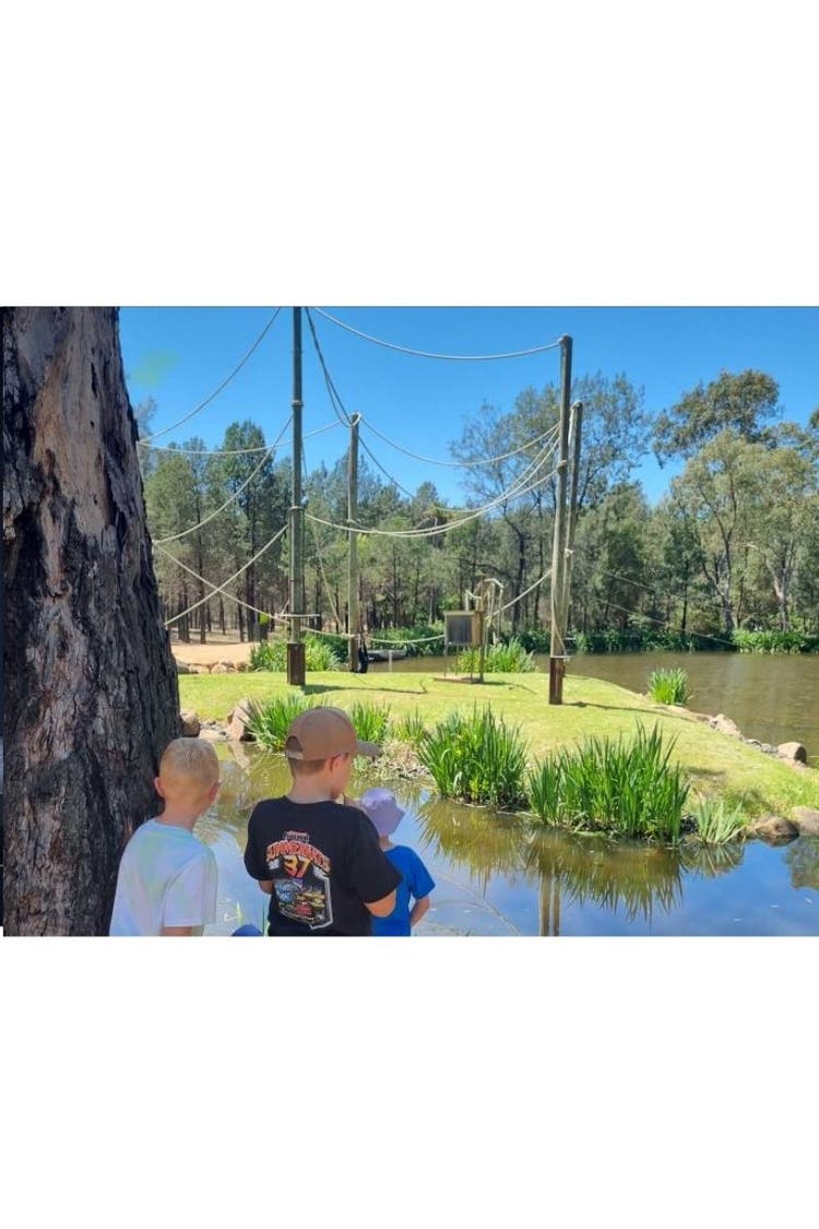 Wamoon students at Dubbo zoo, standing in front of a monkey enclosure with lots of ropes for the monkeys to swing on.